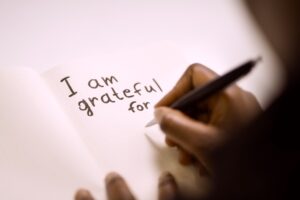 Addict in recovery writing on a gratitude journal